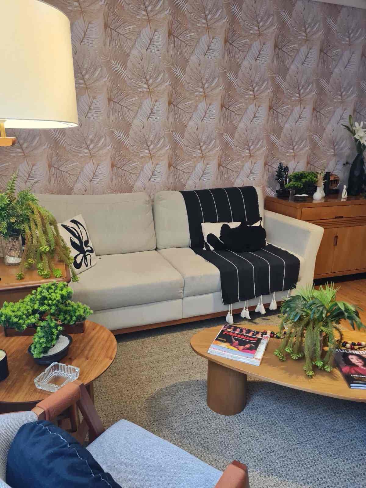 Sala de estar com sofá amplo e decoração verde