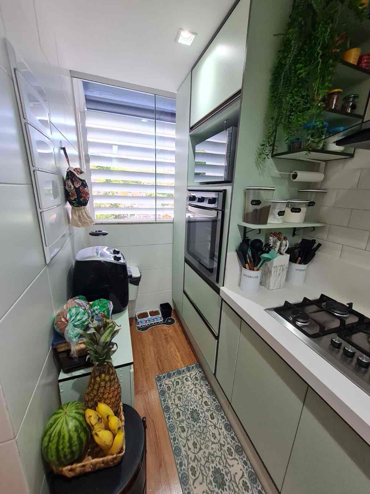 Cozinha com cooktop, forno embutido e armários sob medida
