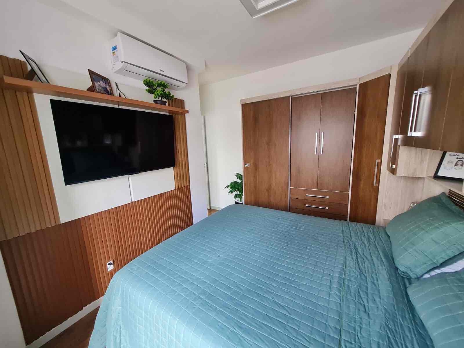 Suíte com painel de TV e ar-condicionado